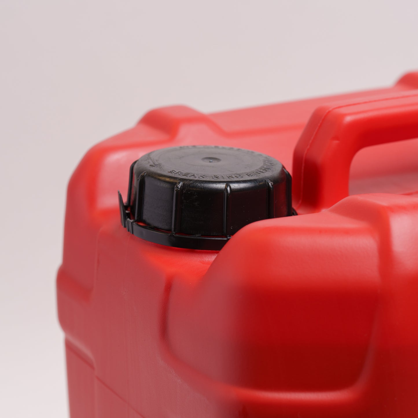 Red plastic container with a black cap on a light gray background